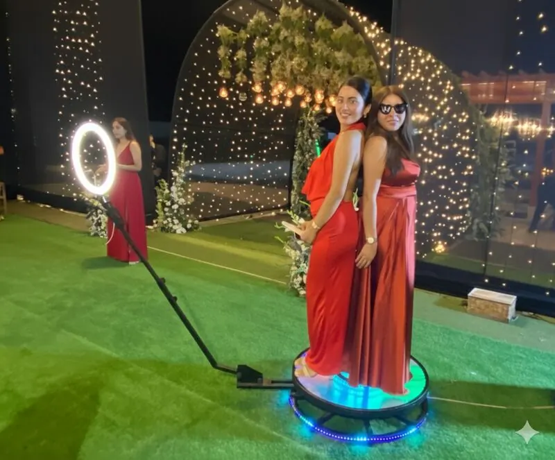 Invitadas posando en la Plataforma 360 VIP Espejada de Giros 360° en una boda con arco de flores